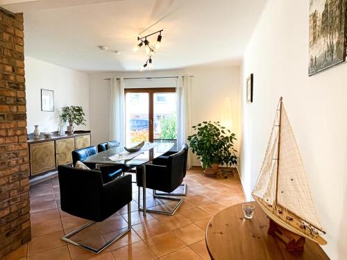 una sala da pranzo con tavolo e barca a vela sul muro di Herzensort - Schönes Haus mit Terrasse und Gartenblick a Rödermark
