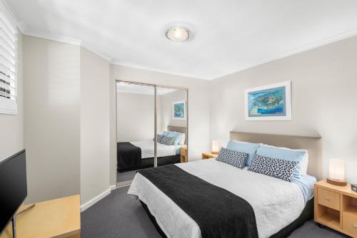 a bedroom with a large bed and a mirror at Lorne beach views at the cumberland in Lorne