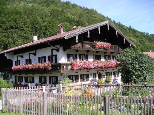 a house with flowers in front of a fence at Bauernhof Hamberger Hof in Sachrang