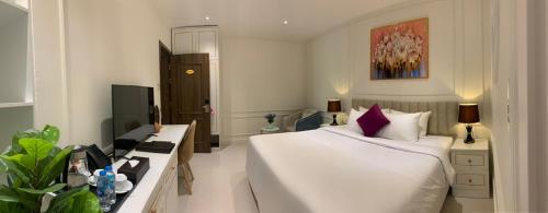 a bedroom with a large white bed and a tv at Khách sạn LAVENDER - Vincom Tây Ninh in Tây Ninh