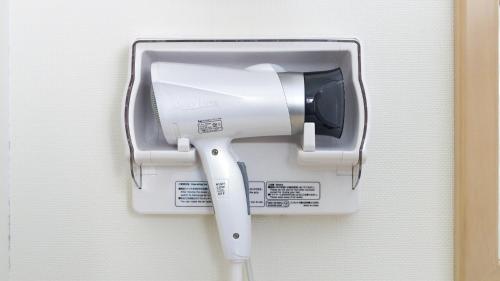 a white paper towel dispenser on a wall at Toyoko Inn Shizuoka eki Kita guchi in Shizuoka