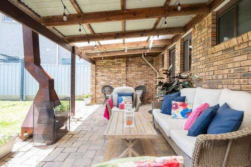 a patio with a white couch and a table at Tranquil Retreat in Ulladulla