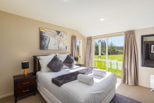 a bedroom with a large bed and a large window at The Meadows Villa in Christchurch