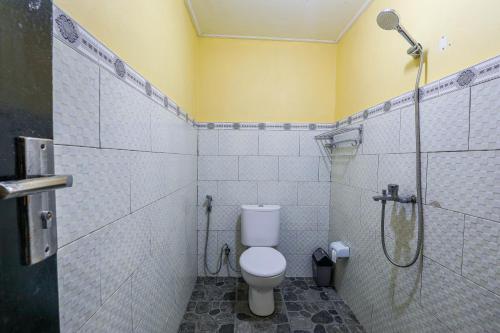 a bathroom with a shower and a toilet and a glass shower at The Salang Guest House in Nusa Penida