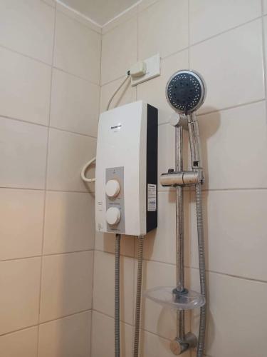 La salle de bains est pourvue d'un sèche-cheveux sur le mur. dans l'établissement Budget Condotel, à Manille