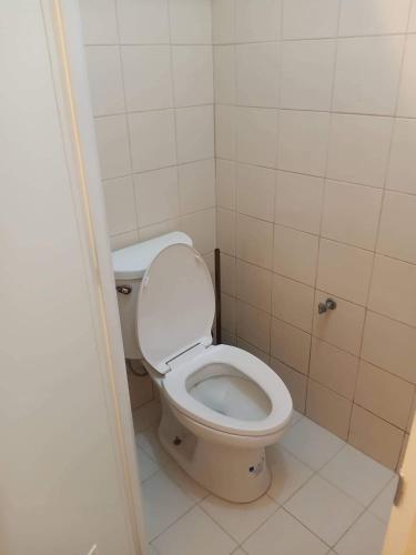 ein Bad mit einem weißen WC in einem Zimmer in der Unterkunft Budget Condotel in Manila