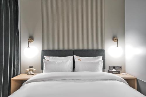 a bedroom with a large bed with white sheets and pillows at Browndot Terrace Pohang Passenger Terminal in Pohang