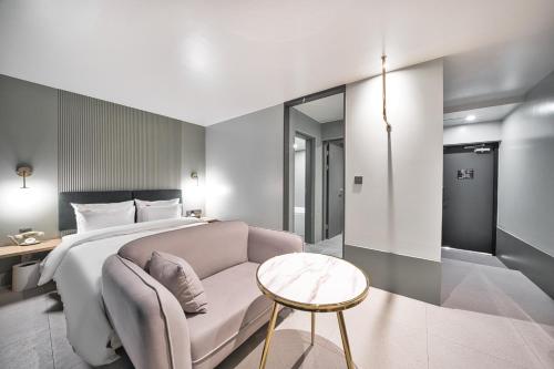 a bedroom with a bed and a couch and a table at Browndot Terrace Pohang Passenger Terminal in Pohang