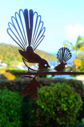 a bird ornament with two birds sitting on a branch at Harbour View Retreat Mangonui in Mangonui