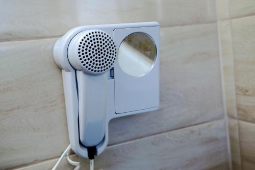 a blue hair dryer hanging on a wall at Dimitropoulos Apartments in Eleonas
