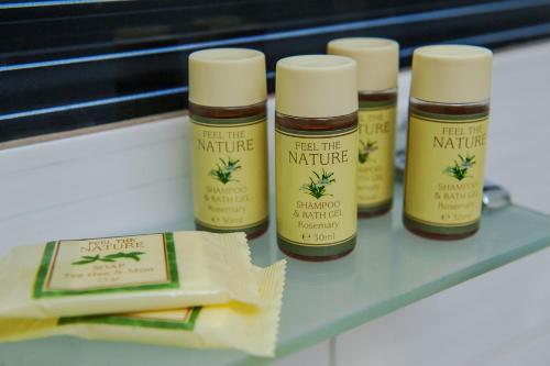 a shelf with four bottles of natural products on it at Dimitropoulos Apartments in Eleonas