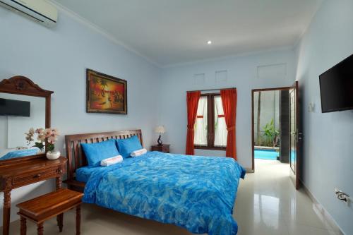 1 dormitorio con cama, mesa y espejo en Graha Wedha Suite Kuta by kamara, en Kuta