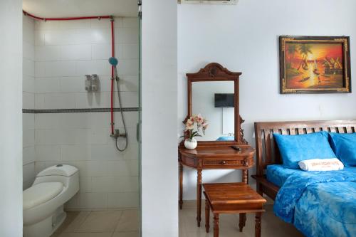 uma casa de banho com uma cama, um WC e um lavatório. em Graha Wedha Suite Kuta by kamara em Kuta
