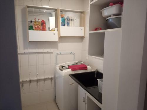 una pequeña cocina blanca con fregadero y lavavajillas en Aconchegante apartamento em Itapema 300 mts praia, en Itapema