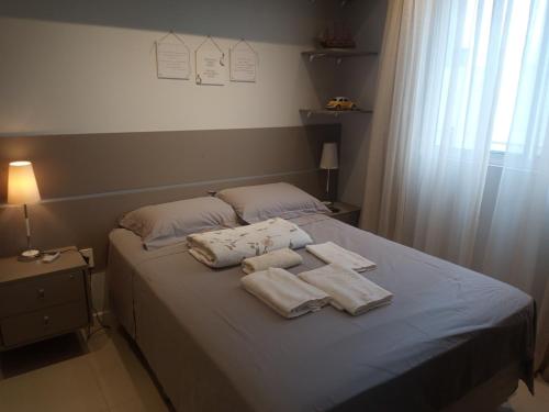 Una cama con toallas encima. en Aconchegante apartamento em Itapema 300 mts praia, en Itapema