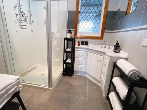 La salle de bains est pourvue d'une douche et d'un lavabo. dans l'établissement Stunning Hobart 3-bed home- close to shopping centers, à Glenorchy