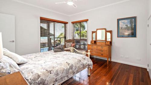 Un dormitorio con una cama, una cómoda y ventanas. en Beautiful View Corlette, en Corlette