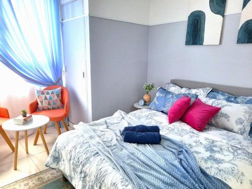 1 dormitorio con 1 cama con almohadas rosas y azules en Horizon Suites, KLIA, en Sepang