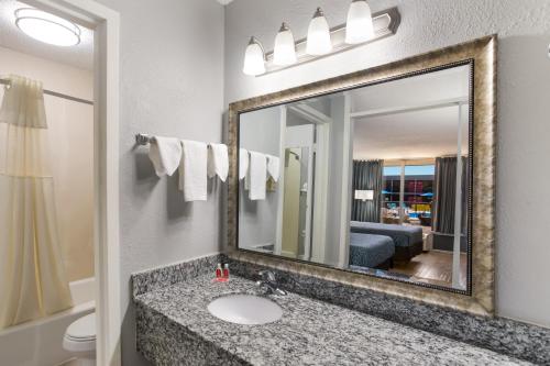 La salle de bains est pourvue d'un lavabo et d'un miroir. dans l'établissement Econo Lodge, à Cave City