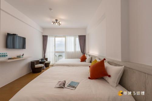 um quarto de hotel com duas camas e uma televisão em Come here em Yanliau