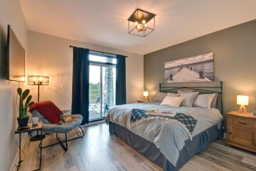 um quarto com uma cama, uma cadeira e uma janela em Rental condo Tremblant-les-Eaux em Mont-Tremblant