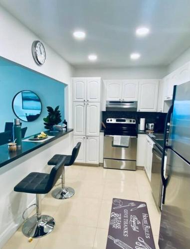 a kitchen with white cabinets and a blue wall at Ocean Reserve Piso 9 - STR 2412 in Miami Beach