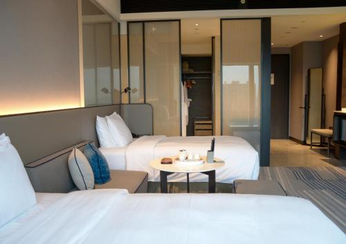 a hotel room with two beds and a table at Crowne Plaza Xiamen Jimei Seaview by IHG-Free Mini Bar in Xiamen