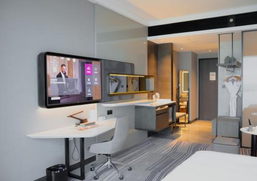 a hotel room with a tv on a wall at Crowne Plaza Xiamen Jimei Seaview by IHG-Free Mini Bar in Xiamen
