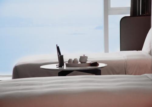 a room with a bed and a table with a candle on it at Crowne Plaza Xiamen Jimei Seaview by IHG-Free Mini Bar in Xiamen