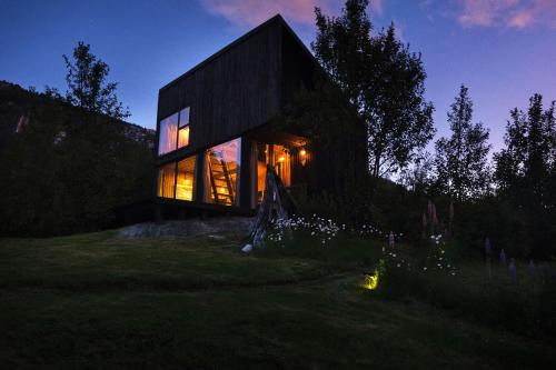 a house on a hill at night with lights at MA PU LODGE Futaleufu in Futaleufú