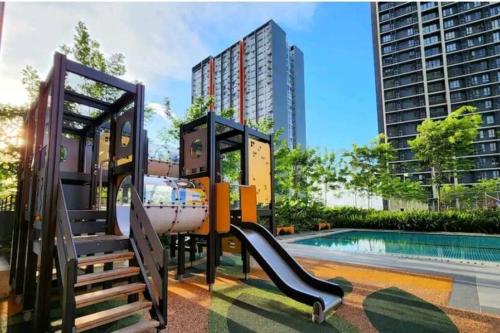 un parque infantil con un tobogán junto a una piscina en 1-7px Klang Bayuemas Staycation Family Lovely Stay Netflix en Klang