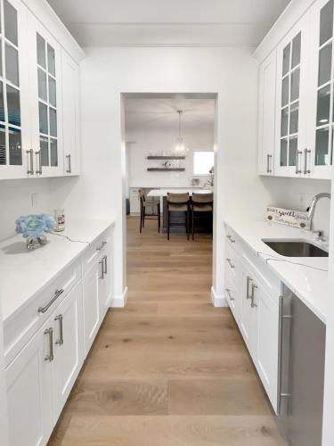 a kitchen with white cabinets and a dining room at New Construction Modern Luxury Retreat w 6 Beds in Southampton