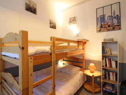 une chambre avec deux lits superposés et une lampe dans l'établissement Appartement T2 bis, balcon, 100m des thermes et commerces, WiFi, 4 pers, La Bourboule - FR-1-608-238, à La Bourboule