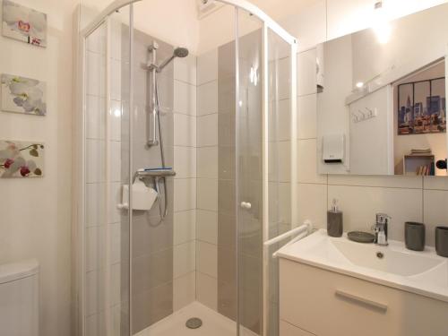 une salle de bain avec douche et lavabo dans l'établissement Appartement T2 bis, balcon, 100m des thermes et commerces, WiFi, 4 pers, La Bourboule - FR-1-608-238, à La Bourboule
