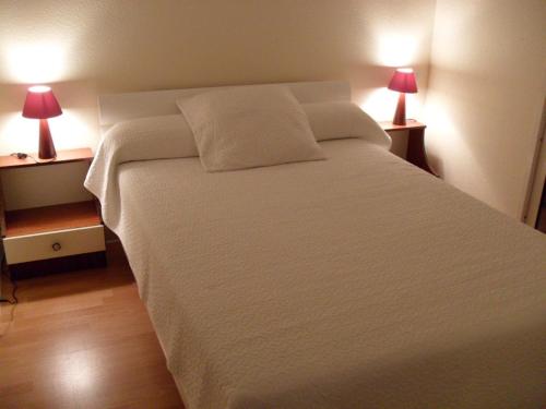 een slaapkamer met een groot wit bed met 2 lampen bij Appartement Royan, 2 pièces, 4 personnes - FR-1-494-140 in Royan