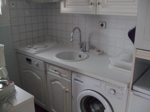 een keuken met een wastafel en een wasmachine bij Appartement Royan, 2 pièces, 4 personnes - FR-1-494-140 in Royan