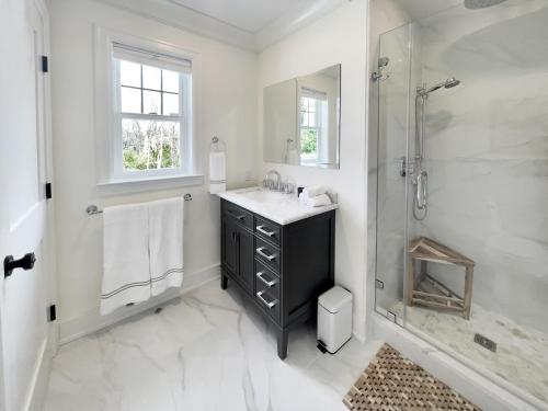 a white bathroom with a sink and a shower at New Construction Modern Luxury Retreat w 6 Beds in Southampton
