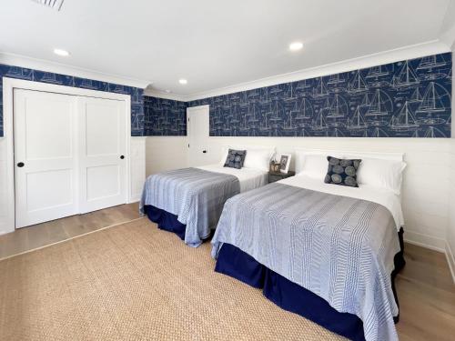 two beds in a room with blue and white at New Construction Modern Luxury Retreat w 6 Beds in Southampton