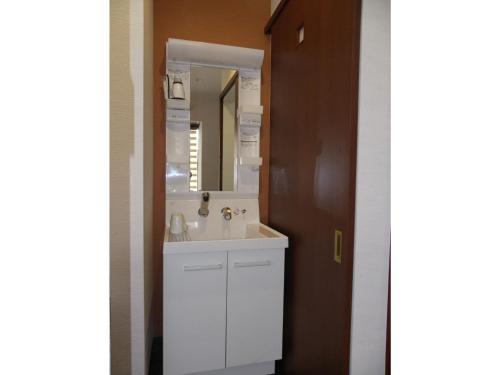 uma casa de banho com um lavatório branco e um espelho. em Guest House Jinya - Vacation STAY 05308v em Takayama