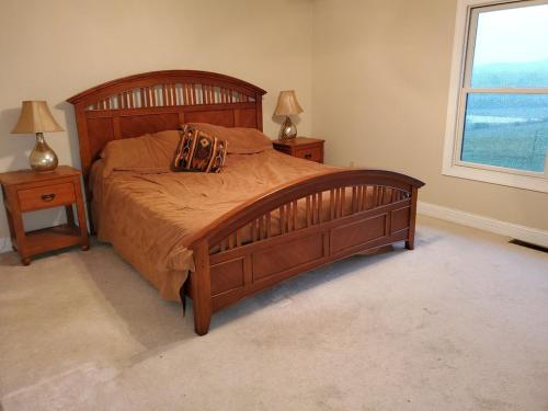 a bedroom with a large wooden bed with two night stands at Secluded house on 60 acres close to Fall Creek Falls in Pikeville