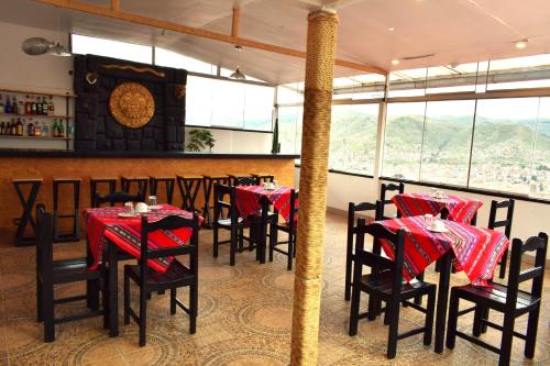 a restaurant with tables and chairs with red tablecloths at Sueños Sambleños in Cusco