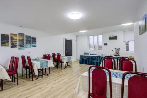 a room with tables and chairs and a kitchen at Olive hotel Kochkor in Kochkorka