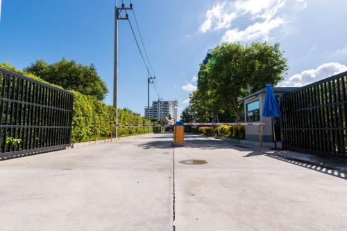 a street with a gate and a sidewalk with trees at Premier Luxe Hotel โรงแรมพรีเมียร์ลักซ์ in Ban Nong Chaeng