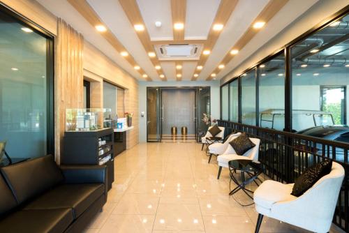 a lobby with a balcony with chairs and tables at Premier Luxe Hotel โรงแรมพรีเมียร์ลักซ์ in Ban Nong Chaeng