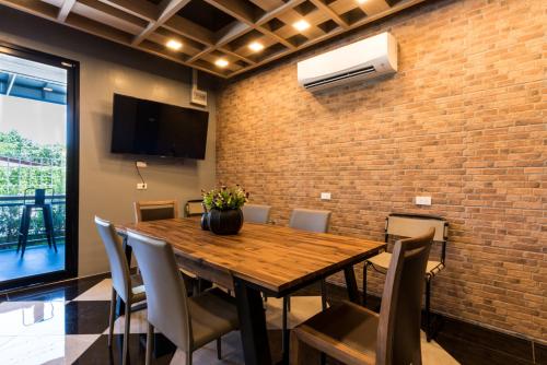 a dining room with a wooden table and chairs at Premier Luxe Hotel โรงแรมพรีเมียร์ลักซ์ in Ban Nong Chaeng
