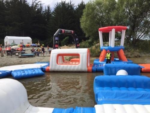 un grupo de equipos inflables de juego de agua en el agua en Camp Taringatura Backpackers en Pukearuhe