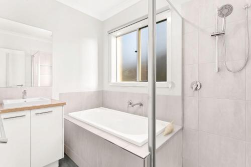 a white bathroom with a shower and a sink at The Seas at Phillip Island in Cowes