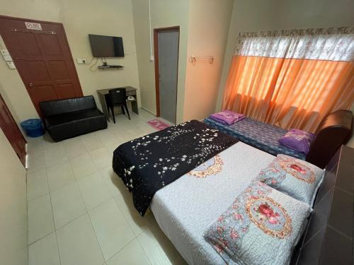 een kamer met een bed en een bank erin bij Ikhlas Roomstay in Kampong Alor Gajah