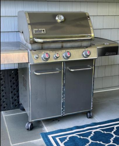 a grill sitting on a patio next to a house at New Construction Modern Luxury Retreat w 6 Beds in Southampton