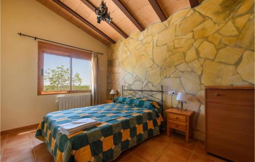 um quarto com uma cama e uma parede de pedra em 1 Bedroom Beautiful Home In Caravaca De La Cruz em Inazares